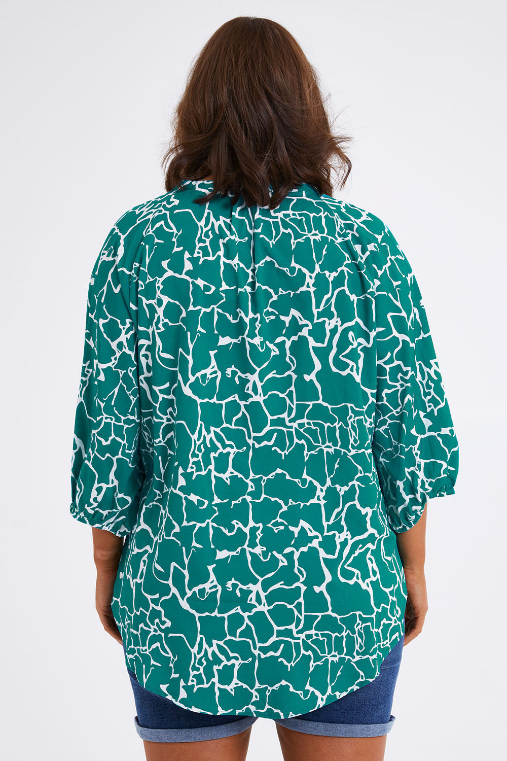 Model Monique wearing size 14 of The Keepers Crew Neck Printed Shirt in colour Tealwhite (Green), from the back