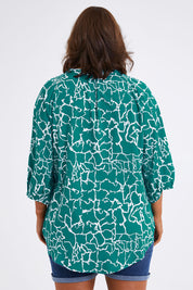 Model Monique wearing size 14 of The Keepers Crew Neck Printed Shirt in colour Tealwhite (Green), from the back