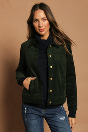 Model Madeline wearing size 10 of The Keepers Cord Jacket in colour Deepforest (Green), from the front, showing the whole outfit
