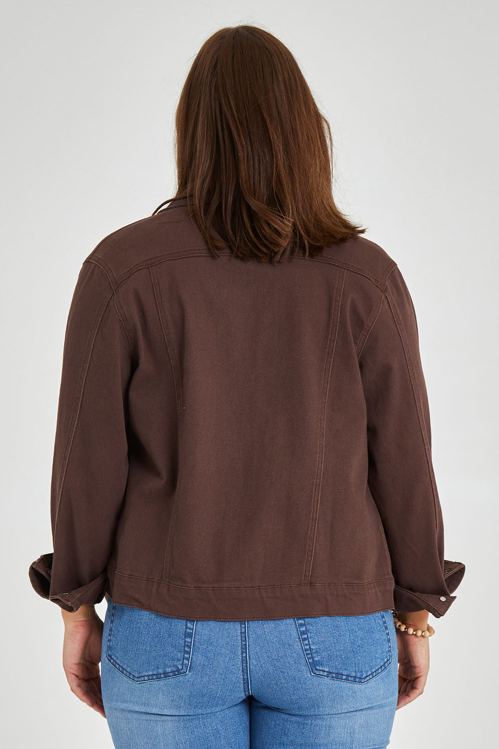 Model Monique wearing size 14 of The Slim Fit Denim Jacket in colour Chocolate, from the back