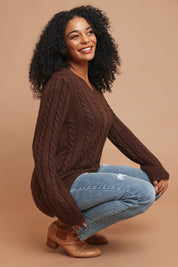 Model Ziara wearing size S of The V Neck Cable Knit Jumper in colour Coffeebean, from the front, showing the whole outfit