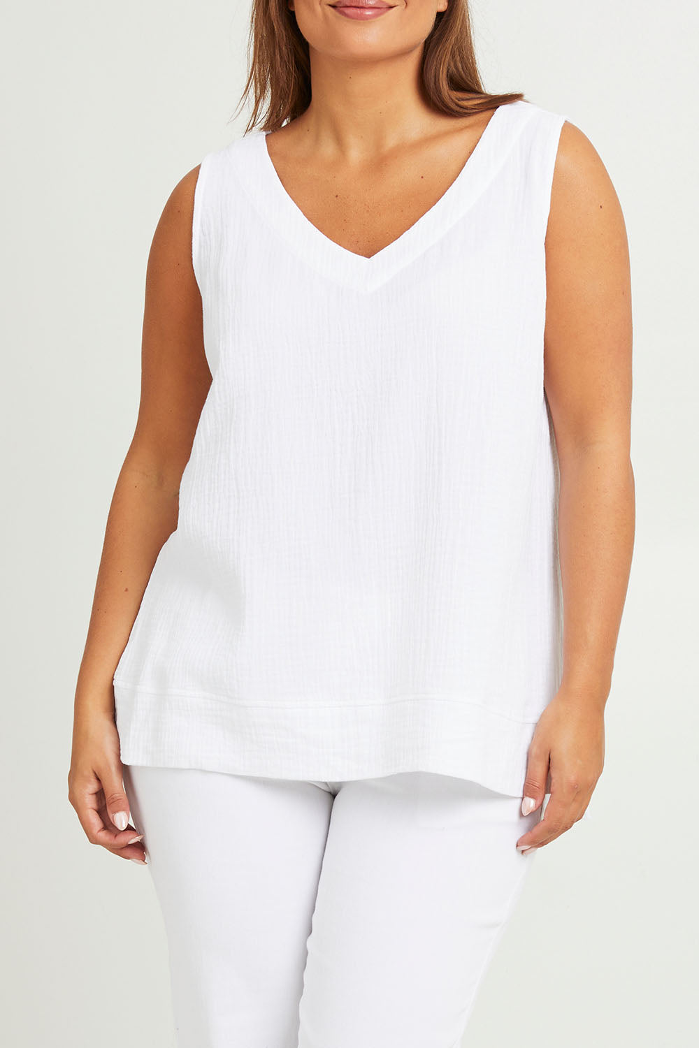 Model Monique wearing size 14 of The Double Cotton V Tank in colour White (White), from the front, cropped image