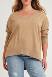 Model Chanel wearing size XL of The High Low V Neck Jumper in colour Fawn, from the front, cropped image