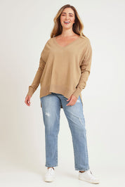 Model Chanel wearing size XL of The High Low V Neck Jumper in colour Fawn, from the front, showing the whole outfit