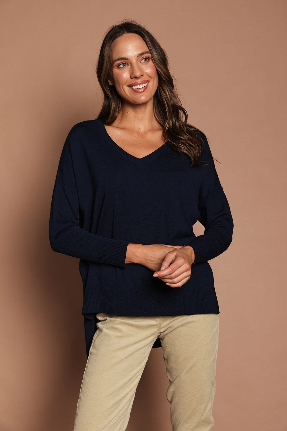 Model Madeline wearing size S of The High Low V Neck Jumper in colour Navy (Blue), from the front, showing the whole outfit