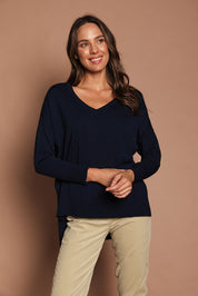 Model Madeline wearing size S of The High Low V Neck Jumper in colour Navy (Blue), from the front, showing the whole outfit