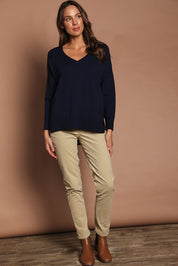 Model Madeline wearing size S of The High Low V Neck Jumper in colour Navy (Blue), from the front, showing the whole outfit