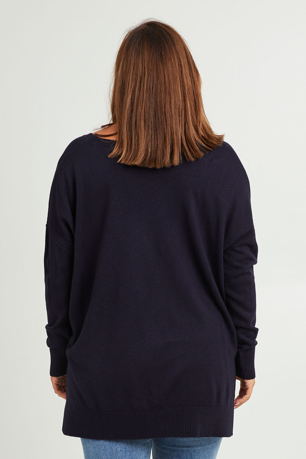 Model Monique wearing size L of The High Low V Neck Jumper in colour Navy (Blue), from the back