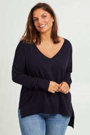 Model Monique wearing size L of The High Low V Neck Jumper in colour Navy (Blue), from the front, cropped image