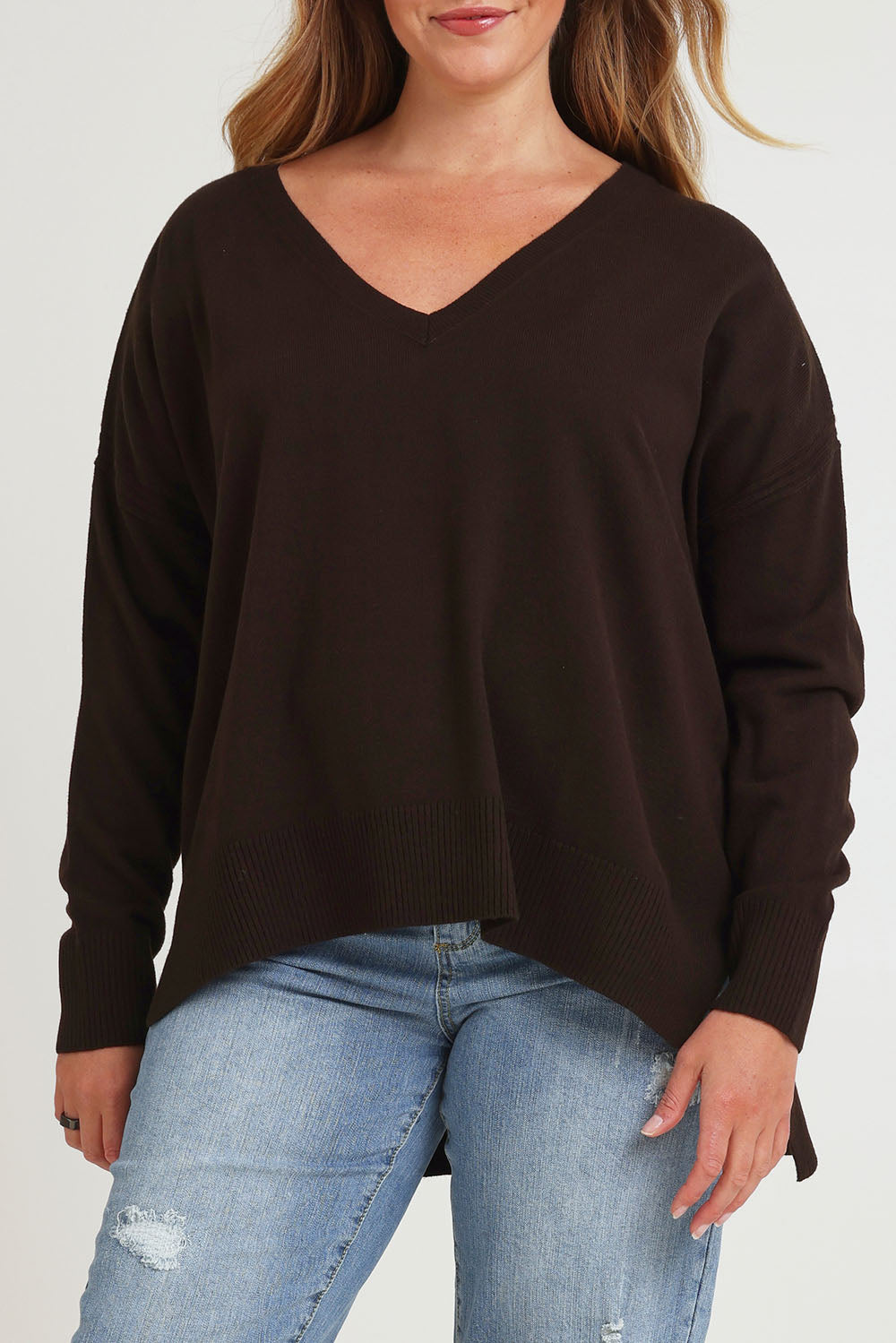 Model Chanel wearing size XL of The High Low V Neck Jumper in colour Sable, from the front, cropped image