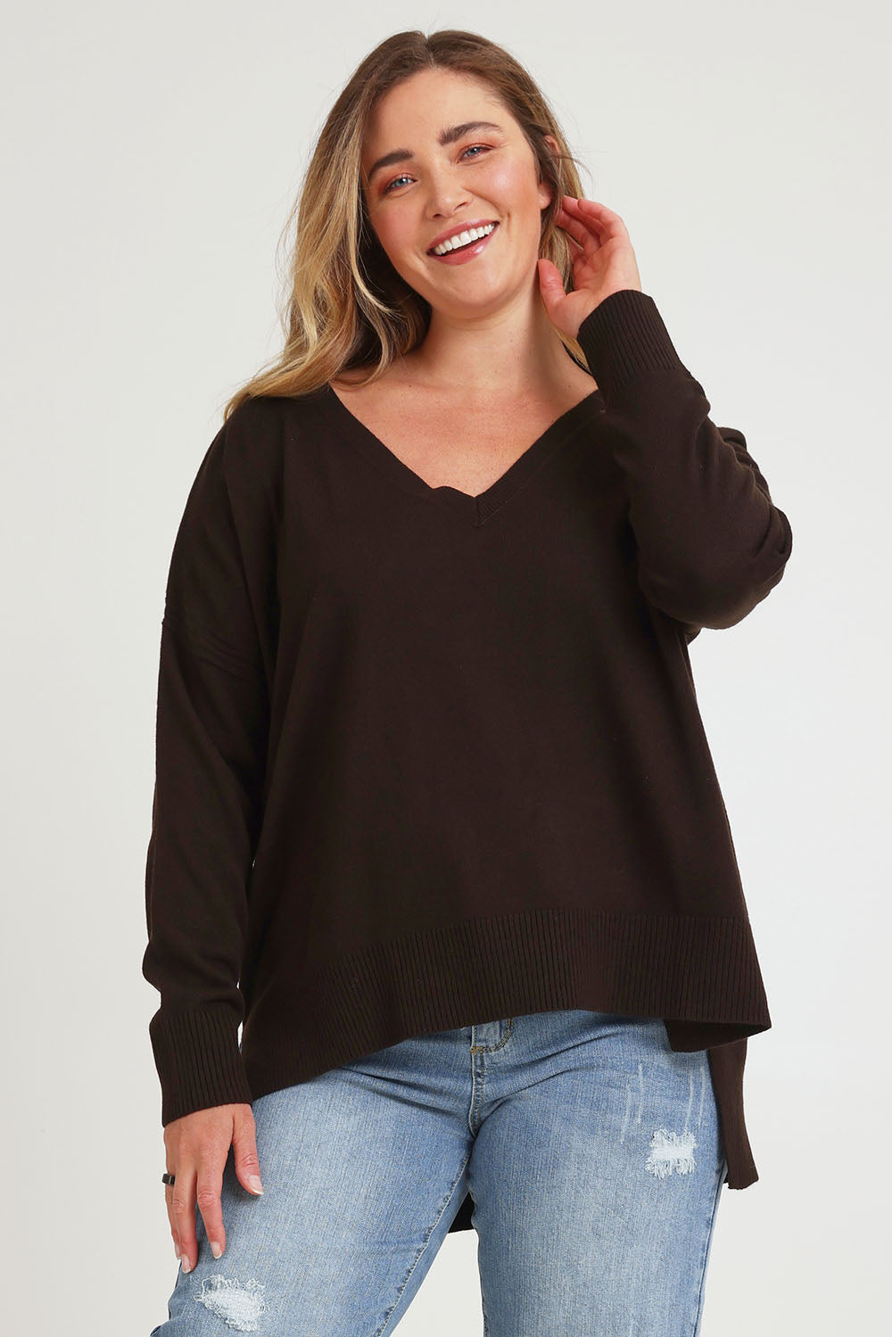 Model Chanel wearing size XL of The High Low V Neck Jumper in colour Sable, from the front, cropped image