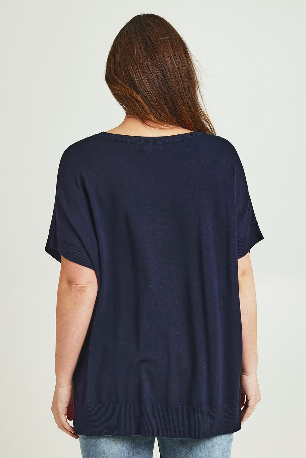 Model Jane wearing size L of The All Season V Neck High Low Tee in colour Darklapis (Blue), from the back