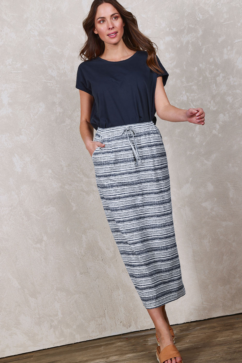 Model Madeline wearing size 10 of The Striped Pull On Skirt in colour Navystripe (Blue), from the front, showing the whole outfit