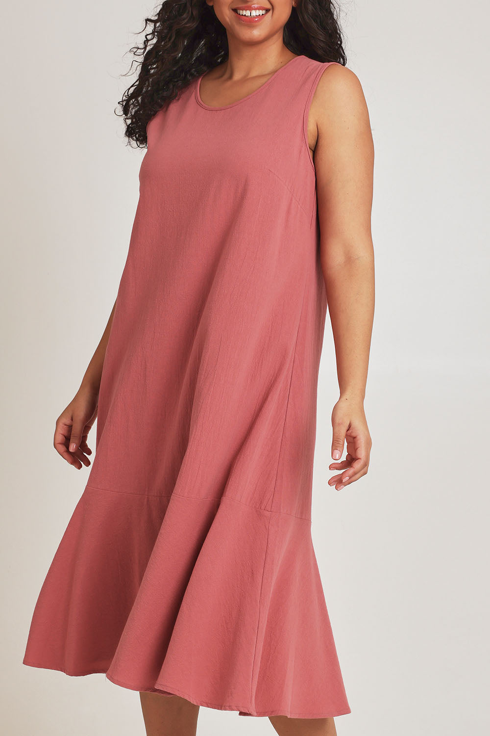 Model Terri-Leigh wearing size 14 of The Cotton Flounce Dress in colour Rose (Pink), from the front, cropped image