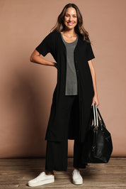 Model Madeline wearing size 10 of The Pack & Go Luxe Bamboo Button Up Dress with Pockets in colour Black (Black), from the front, showing the whole outfit