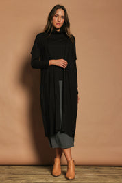 Model Madeline wearing size 10 of The Pack & Go Luxe Bamboo Button Up Dress with Pockets in colour Black (Black), from the front, showing the whole outfit