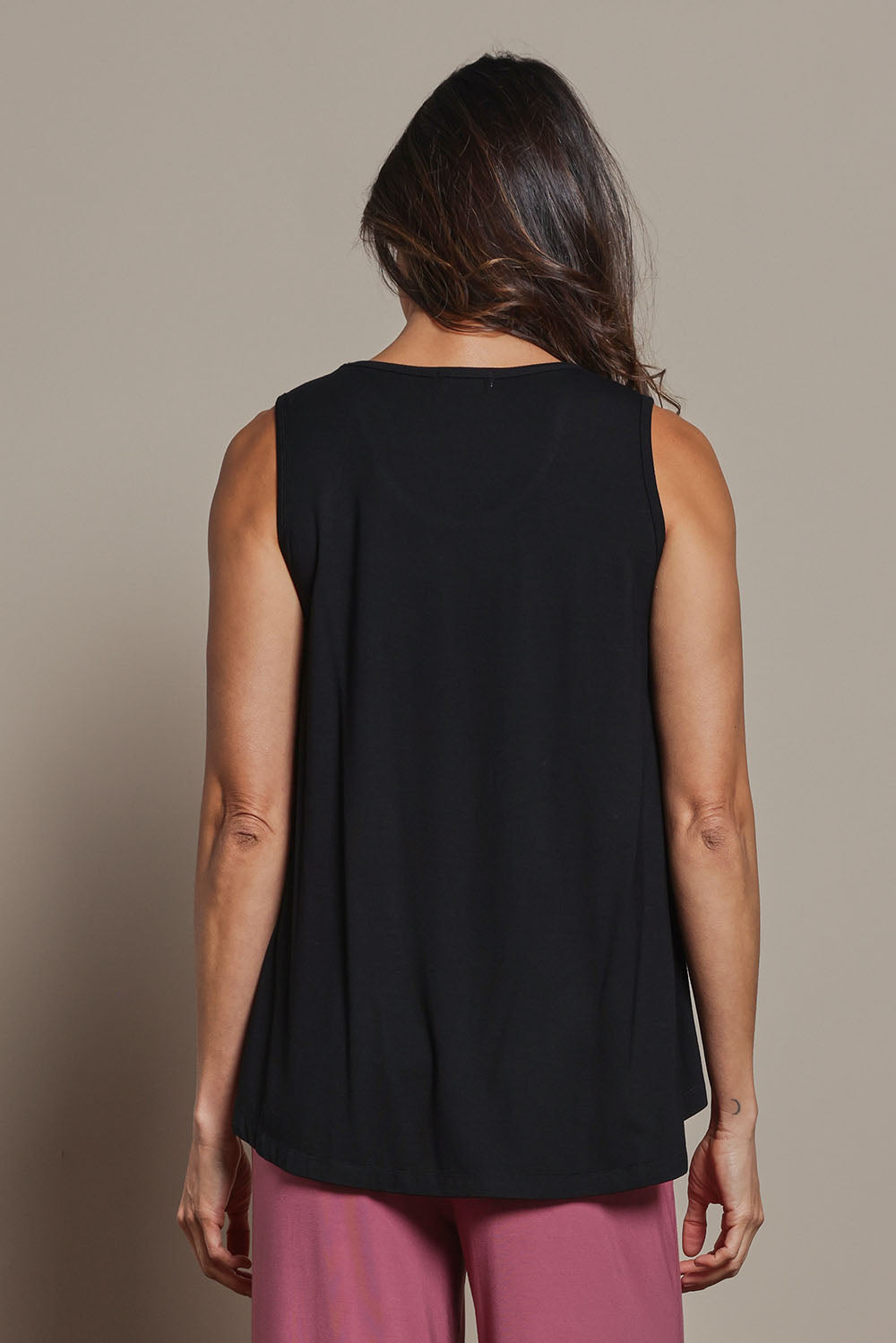 Model Amanda wearing size 10 of The Pack & Go Luxe Bamboo Swing Tank in colour Black (Black), from the back