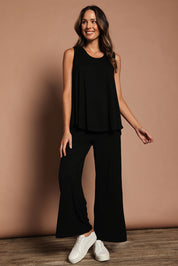 Model Madeline wearing size 10 of The Pack & Go Luxe Bamboo Swing Tank in colour Black (Black), from the front, showing the whole outfit