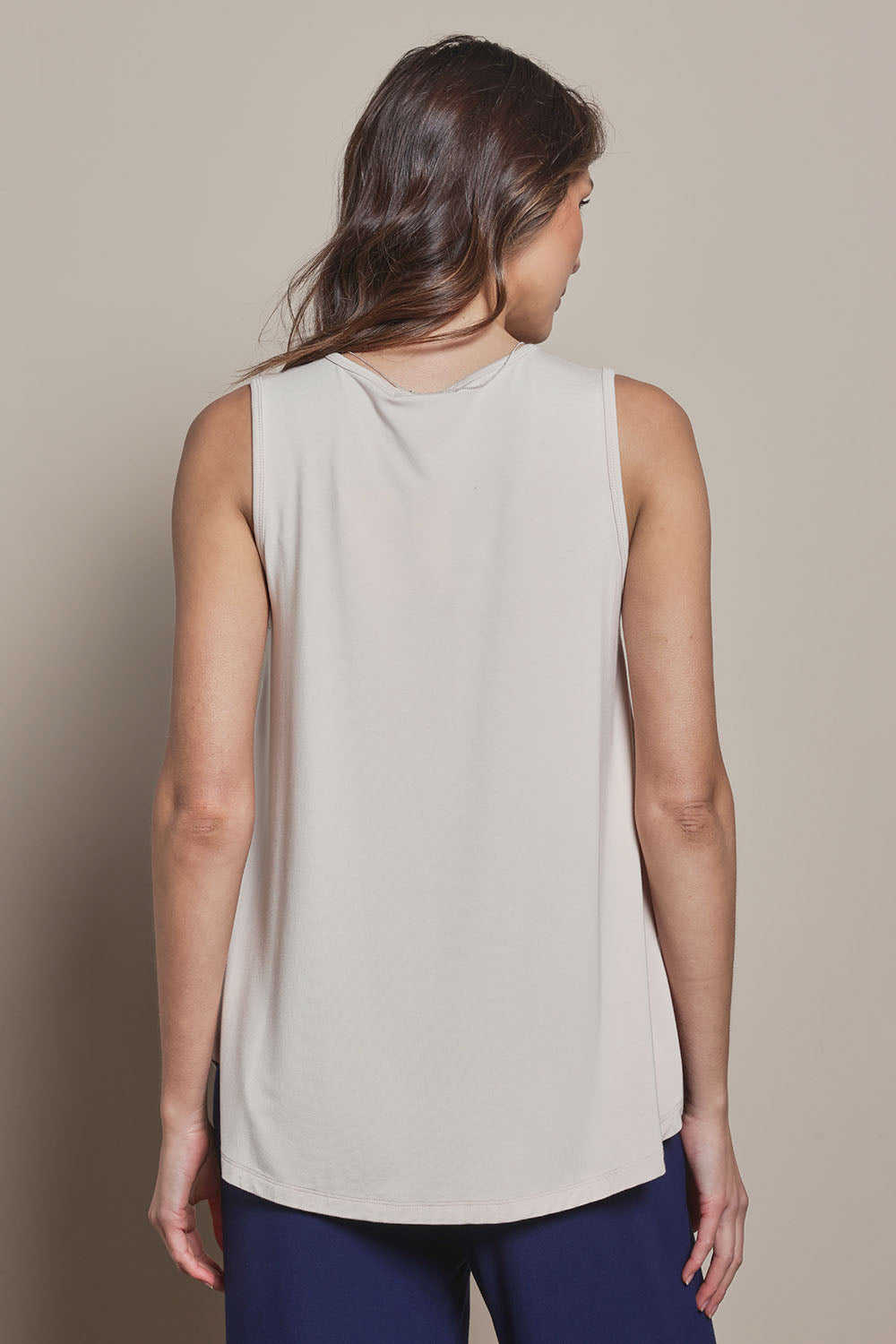Model Madeline wearing size 10 of The Pack & Go Luxe Bamboo Swing Tank in colour Nougat, from the back