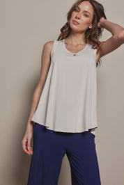Model Madeline wearing size 10 of The Pack & Go Luxe Bamboo Swing Tank in colour Nougat, from the front, cropped image