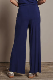 Model Amanda wearing size 10 of The Pack & Go Luxe Bamboo Wide Leg Pant in colour Frenchnavy (Blue), from the back