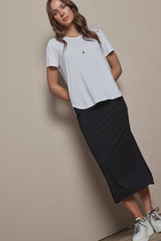 Model Madeline wearing size 10 of The Pack & Go Luxe Bamboo Pull On Maxi Skirt in colour Black (Black), from the front, showing the whole outfit