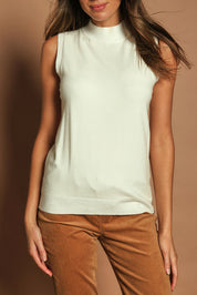 Model Madeline wearing size S of The Modal Blend Mockturtle Vest in colour White (White), from the front, cropped image
