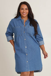 Model Ashleigh wearing size 16 of The Denim Shacket Dress With Pockets in colour Denimblue (Blue), from the front, cropped image