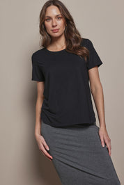 Model Madeline wearing size 10 of The Pack & Go Luxe Bamboo Tee in colour Black (Black), from the front, cropped image