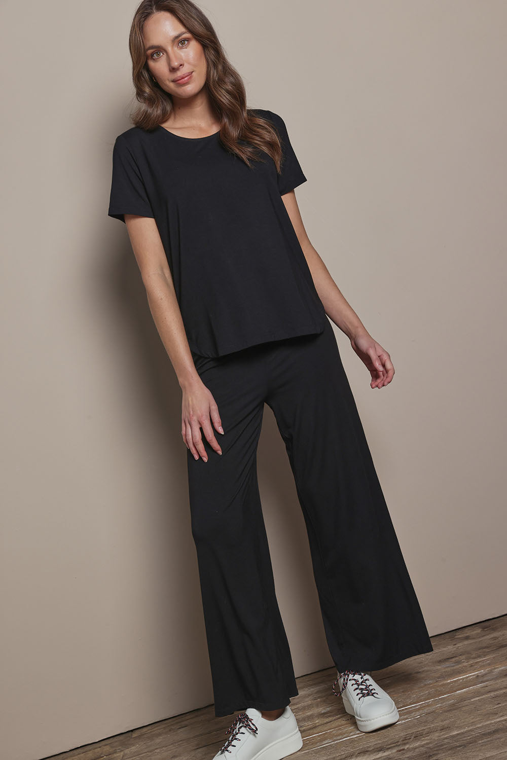Model Madeline wearing size 10 of The Pack & Go Luxe Bamboo Tee in colour Black (Black), from the front, showing the whole outfit