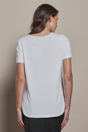 Model Madeline wearing size 10 of The Pack & Go Luxe Bamboo Tee in colour White (White), from the back