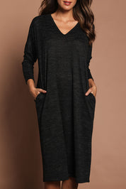 Model Madeline wearing size 10 of The Relaxed L/S Tee Dress With Pockets in colour Blackmarle (Black), from the front, cropped image