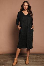 Model Madeline wearing size 10 of The Relaxed L/S Tee Dress With Pockets in colour Blackmarle (Black), from the front, showing the whole outfit
