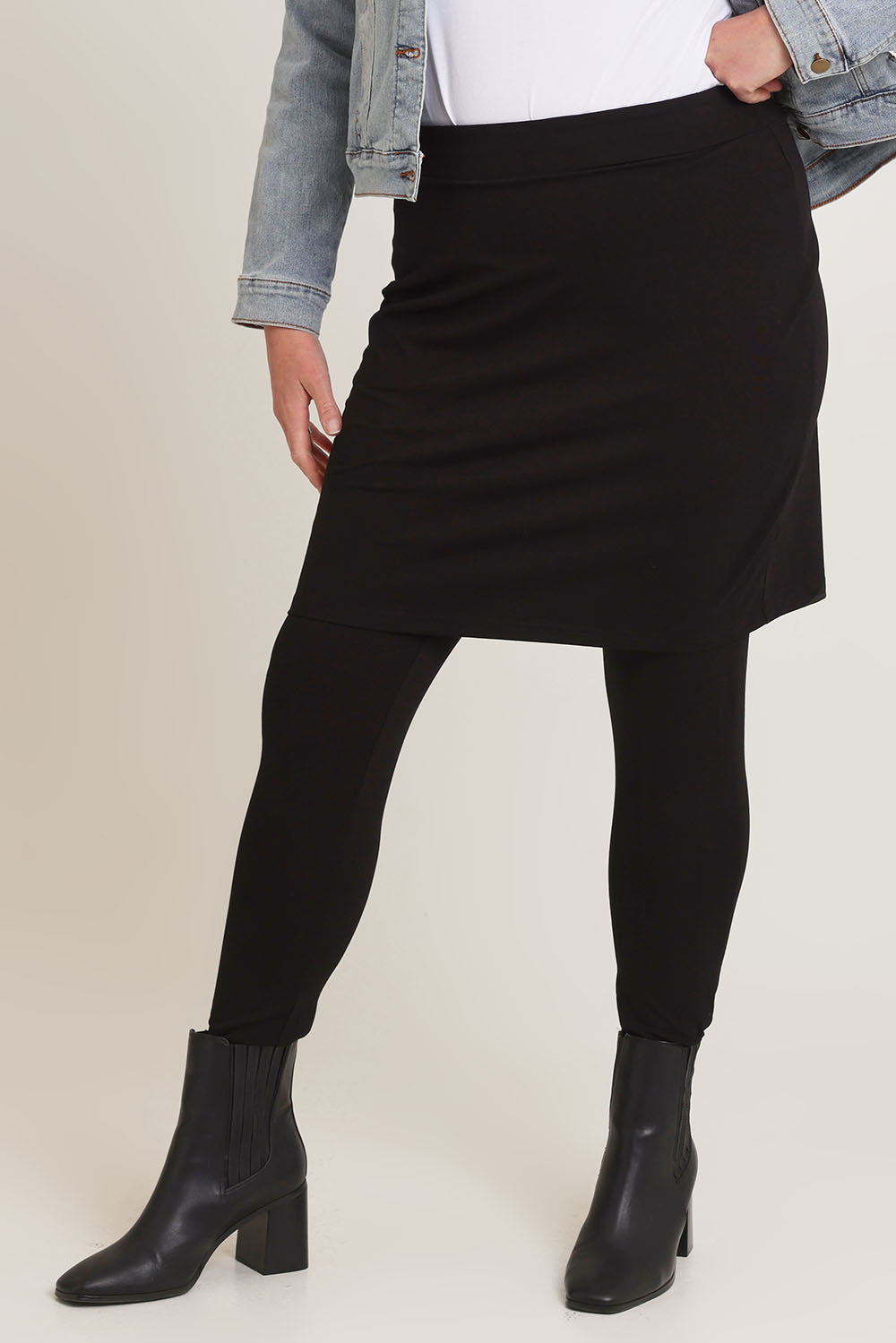 Model Chanel wearing size 16 of The Keepers Skirted Legging in colour Black (Black), from the front, cropped image