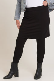 Model Chanel wearing size 16 of The Keepers Skirted Legging in colour Black (Black), from the front, cropped image