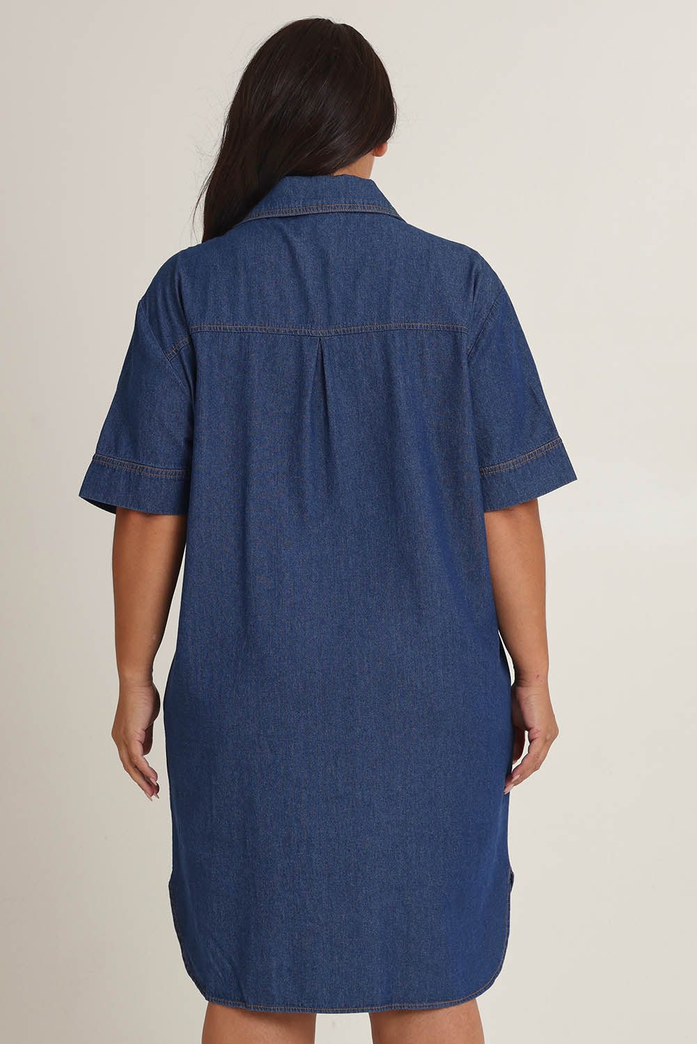 Model Ashleigh wearing size 16 of The S/S Chambray Shacket Dress With Pockets in colour Denim (Blue), from the back