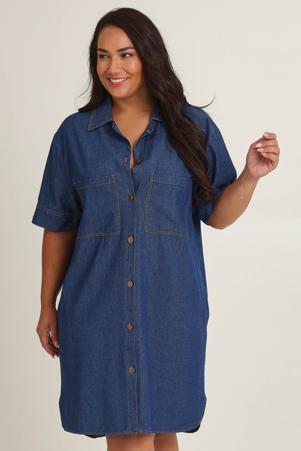 Model Ashleigh wearing size 16 of The S/S Chambray Shacket Dress With Pockets in colour Denim (Blue), from the front, cropped image