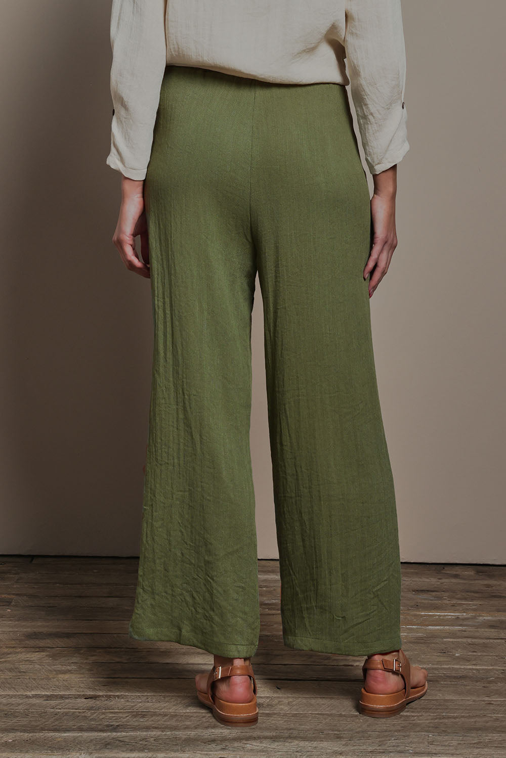 Model Madeline wearing size 10 of The Must Have Linen Look Pull on Pant in colour Kkahi (Green), from the back