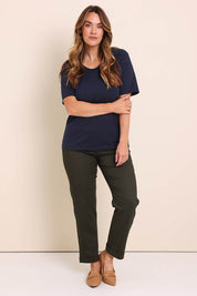 Model Lauraw wearing size 14 of the The Teachers Cotton Pant With Pockets - Pinegrove in colour Pinegrove, from the front