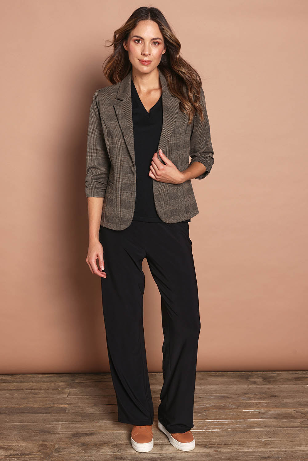 Model Madeline wearing size 10 of The Travel Wide Leg Pant in colour Black (Black), from the front, showing the whole outfit