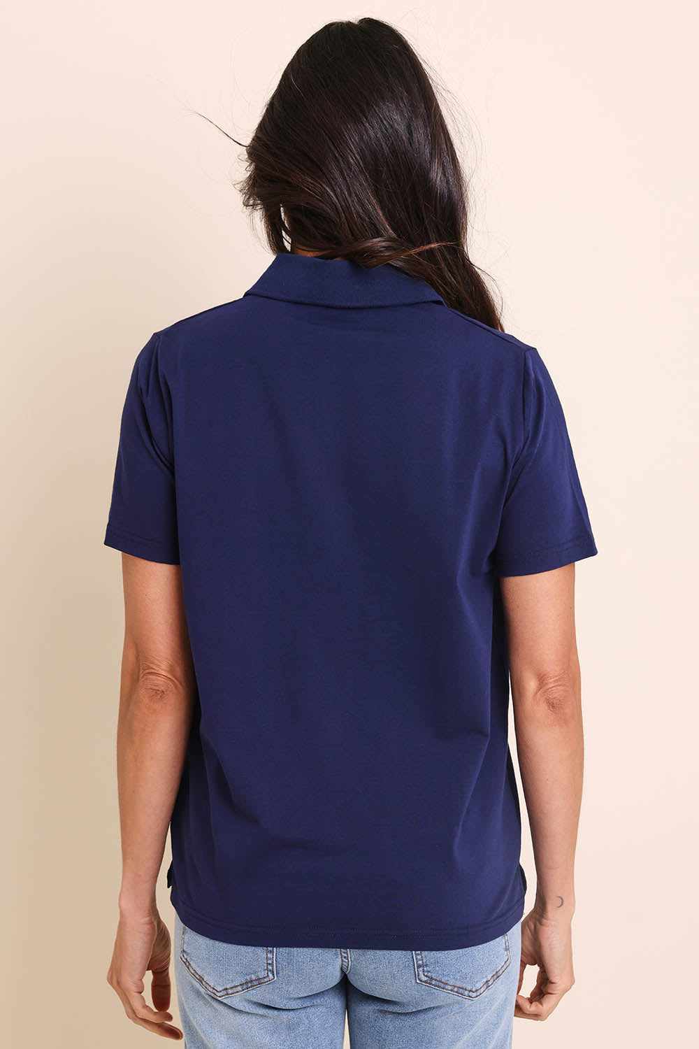 Model Amandam wearing size 10 of the The Keepers Polo Tee – Navy in colour Navy, from the back