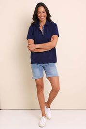 Model Amandam wearing size 10 of the The Keepers Polo Tee – Navy in colour Navy, from the front