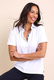 Model Amandam wearing size 10 of the The Keepers Polo Tee – White in colour White, in a cropped view