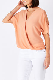 Model Perrie wearing size 10 of The Cut Out Shoulder Blouse in colour Clay, from the front, cropped image
