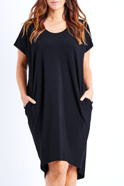 Model Laura wearing size 14 of The Drape Jersey Dress in colour Black (Black), from the front, cropped image