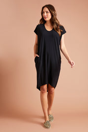 Model Madeline wearing size 10 of The Drape Jersey Dress in colour Black (Black), from the front, showing the whole outfit