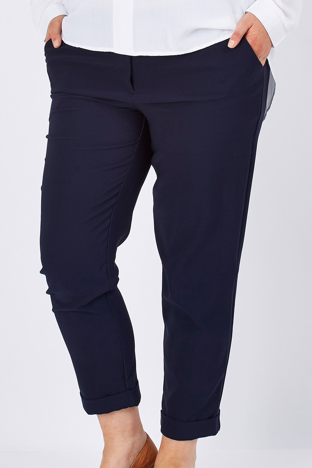 Model Jess wearing size 14 of The Soft Ankle Grazer Pant in colour Navy (Blue), from the front, cropped image