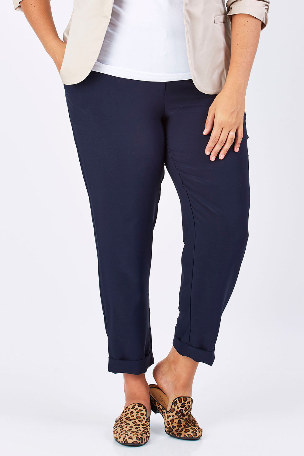 Model Mae wearing size 18 of The Soft Ankle Grazer Pant in colour Navy (Blue), from the front, cropped image