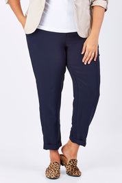 Model Mae wearing size 18 of The Soft Ankle Grazer Pant in colour Navy (Blue), from the front, cropped image