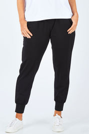 Model Laura wearing size 14 of The Basic Keeper Pant in colour Black (Black), from the front, cropped image